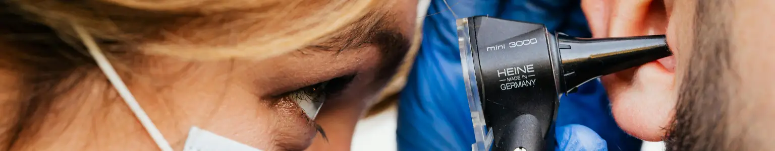 ENT physician examining a moist ear canal in a patient with chronic otitis externa