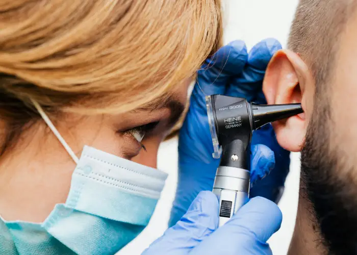 ENT physician examining a moist ear canal in a patient with chronic otitis externa